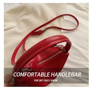 Detail of red wrinkled patent leather handbag featuring thick handles and silver zipper