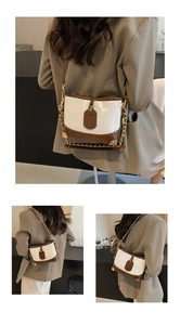 Detail view of contrast stitching bucket bag with gold chain and metal corner accents