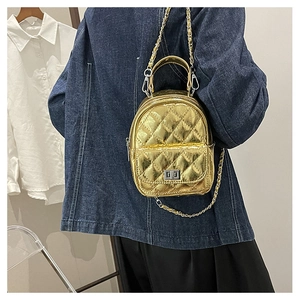 Detail of mini gold quilted leather backpack with silver turn-lock and chain strap