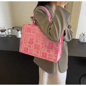 Roze canvas draagtas met rode Dubbel Geluk-prints getoond in een stijlvolle omgeving
