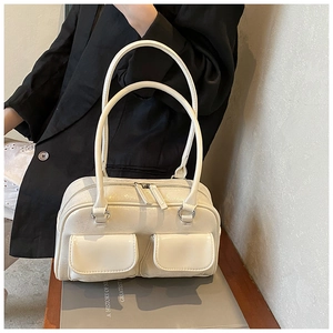 Detail of cream white faux leather bowling bag with vintage cracked texture and twin pockets