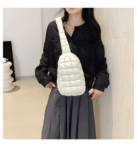 Detailed view of quilted white nylon crossbody bag with puffy texture and wide strap