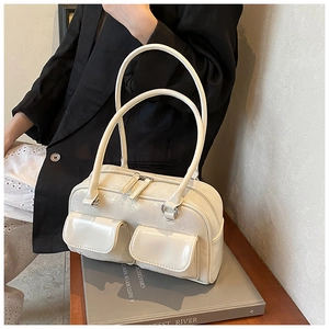 Detail of cream glossy faux leather bowling bag with double front flap pockets