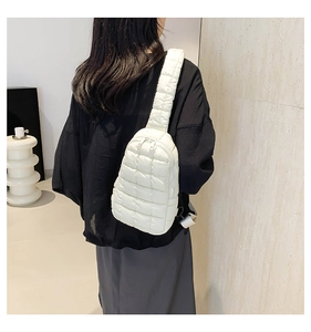 Detail of white quilted nylon crossbody bag showing soft puffer texture and zipper