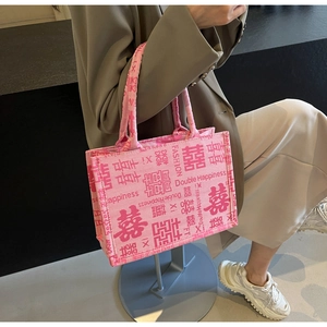 Detail der rosa Canvas-Tasche mit roter Doppelglück-Stickerei und stabilen Tragegriffen
