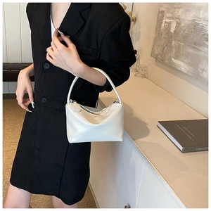 Close-up of white lychee leather shoulder bag with silver zipper and minimalist design