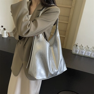 Silver metallic tote bag with crinkled texture shown on shoulder for a stylish look