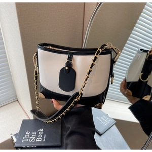Detail of high-gloss leather bucket bag with gold hardware and contrast color design