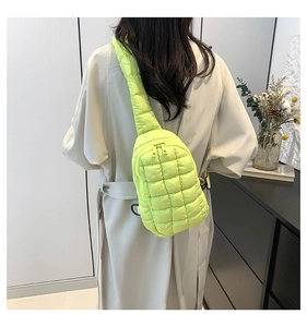Detail of lime green quilted nylon crossbody bag showing puffy texture and dual zippers