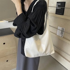 Minimalist cream-colored oil wax leather tote bag shown on model for daily commuting