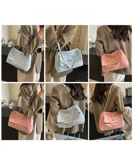 Detail of woven texture flap shoulder bag with metal chain strap in pink and blue