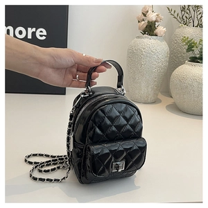 Detail of black quilted leather mini backpack with silver chain strap and top handle