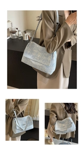 Close-up of light blue tweed woven tote bag with silver chain strap and metal detail