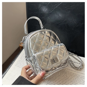 Close-up of a silver quilted mini backpack with metal chain and turn-lock closure