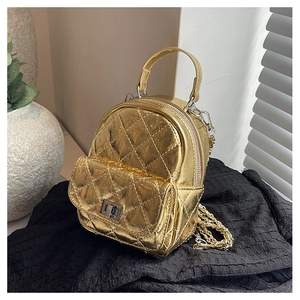 Macro detail of gold metallic quilted mini backpack with chain strap and turn-lock pocket