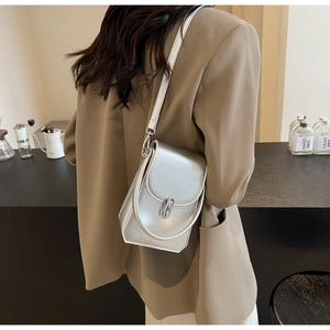 Petit sac bandoulière argenté métallisé porté par un mannequin avec poignée et sangle