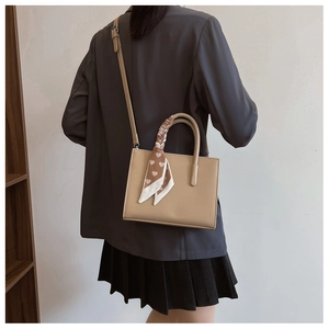 Detailansicht der beigen Tote Bag mit Litschiprägung, Herz-Schal und Umhängeriemen