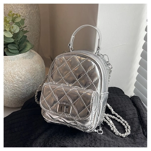 Macro detail of silver quilted mini backpack with chain strap and metallic finish
