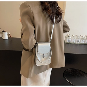 Détail du sac à bandoulière argenté métallisé avec texture cuir et fermoir en métal
