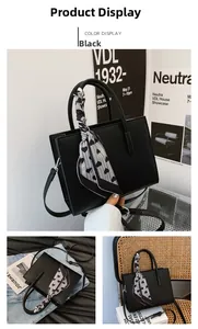 Detail der schwarzen Tote-Bag aus Leder mit Herz-Print Seidenschal-Dekoration am Griff