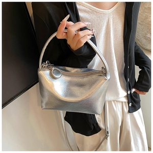 Detail of silver metallic handbag with pleated texture and top zipper closure
