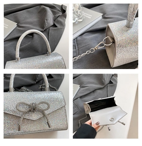 Detail view of silver glitter mini bag with diamond bow buckle and metal chain strap