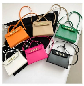 Vista superior de varios bolsos bandolera en seis colores con cierres metálicos dorados