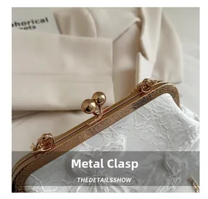 Detailed macro view of vintage floral engraved hardware clasp on a lace shell handbag