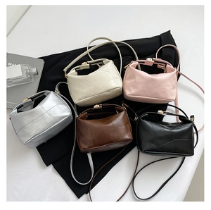 Vue détaillée de cinq sacs bandoulière en argent, beige, rose, marron et noir vus de dessus