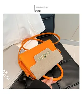 Detail of orange leather and tweed拼接 shoulder bag with gold metal rotary lock closure