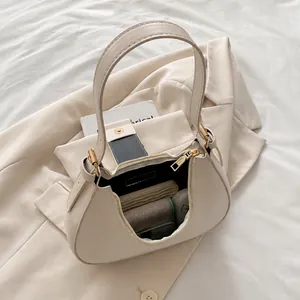 Interior view of beige crescent bag showing capacity for long wallet and daily essentials