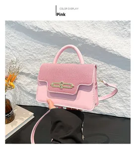 Detail of pink PU leather and twill fabric handbag with gold buckle and top handle