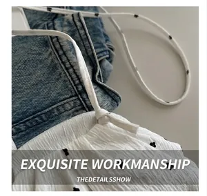 Détail de tissu texturé à fleurs blanches avec fines bretelles et décolleté à volants