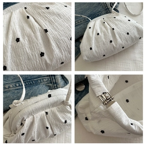Détail du sac à bandoulière blanc à volants avec broderie florale et texture plissée