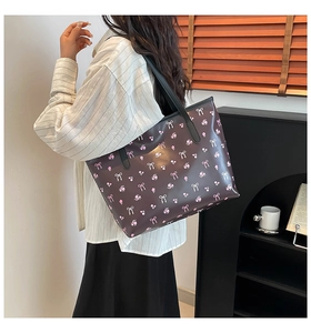 Détail d'un grand sac cabas fleuri avec nœuds roses porté à l'épaule pour les cours