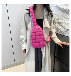 Hot pink quilted nylon crossbody chest bag shown on model with wide shoulder strap