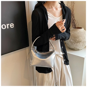 Detail view of the silver pleated handbag showing textured material and metallic handles