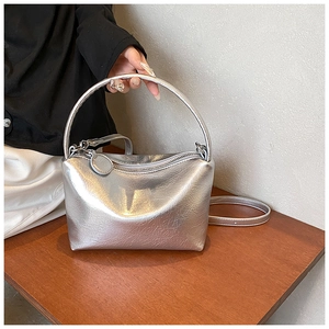 Detailed view of silver metallic handbag with pleated texture and adjustable strap
