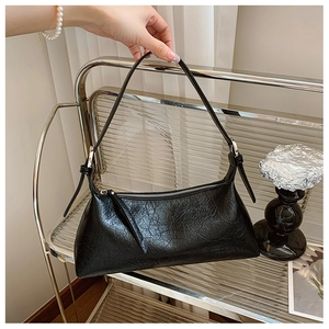 Detail of black wrinkled oil wax leather texture and silver buckle on shoulder bag
