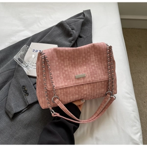 Detail of pink woven tote bag with silver chain strap and metal flap closure