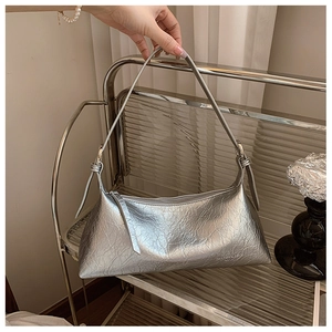 Close-up of silver crinkled patent leather underarm bag with metallic texture and logo