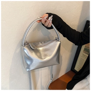 Detail of silver metallic handbag with crinkled texture and adjustable shoulder strap