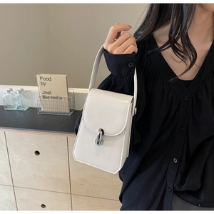 Détail du sac à main blanc crème en similicuir avec texture brillante et fermoir argenté