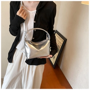 Detail of silver metallic semi-circle handbag with smooth PU texture and sleek zipper