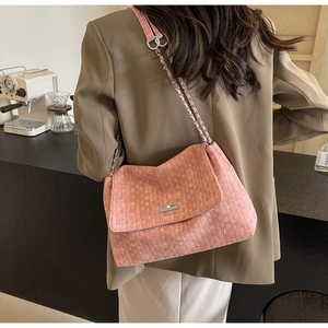 Close-up of pink woven texture tote bag with silver chain strap on model's shoulder