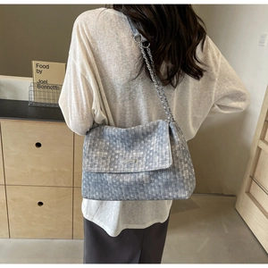 Detail showing woven texture of blue and grey tote bag with silver chain strap