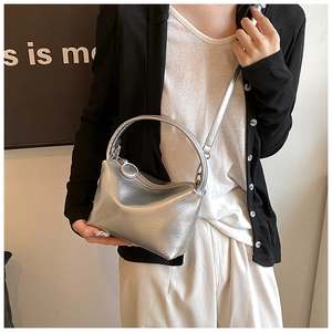 Detail of silver metallic handbag with unique round handle and sleek crossbody strap
