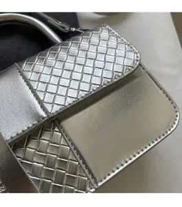 Detail of silver metallic woven handbag showing intricate intrecciato texture and shine