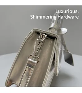 Detail of silver metallic leather handbag showing high-quality metal buckle and hardware
