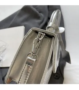 Detail of silver metallic leather handbag showing high-quality metal buckle and hardware